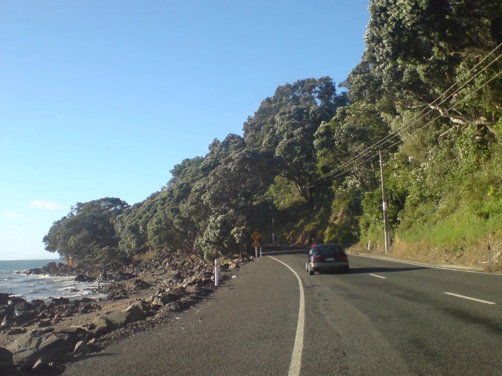 Winding coastal section of State Highway 25 hugging the Coromandel Peninsula shoreline in New Zealand