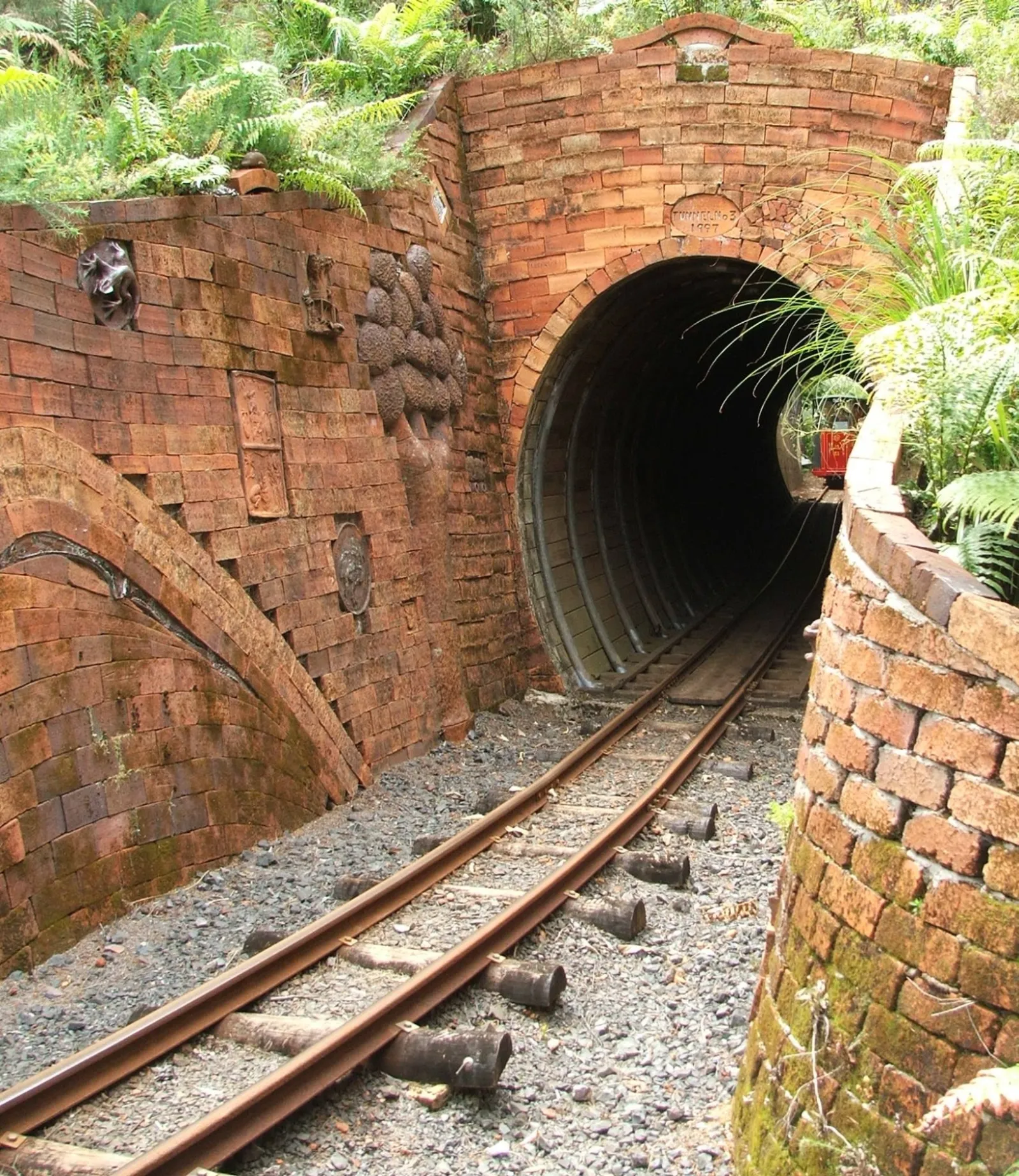 Narrow-gauge Driving Creek Railway train climbing through native bush above Coromandel Town