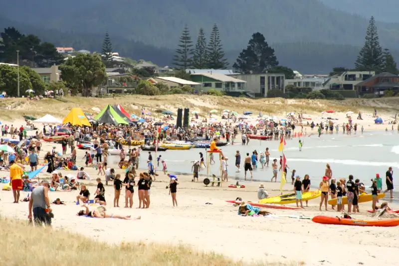 Whangamata Beach panoramic view with golden sand and surf