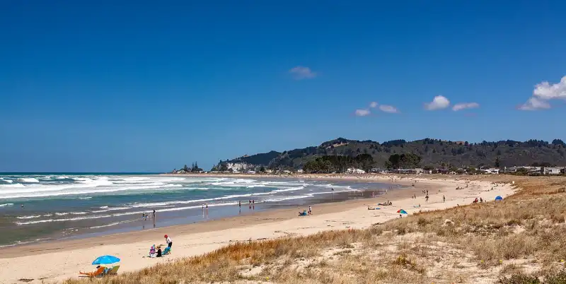 Summer day at Whangamata Beach with clear blue water