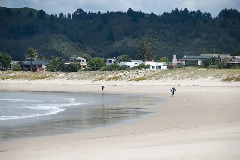 Surfer on the beach in Whangamata, New Zealand
